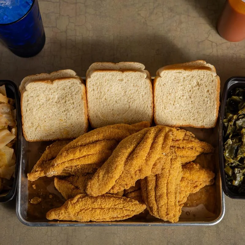 Family tray of hand-battered fried catfish with white bread and Southern sides