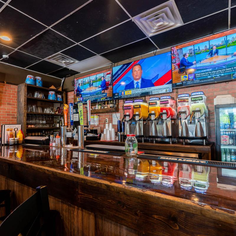 Bar with frozen drink machines and big screen TVs